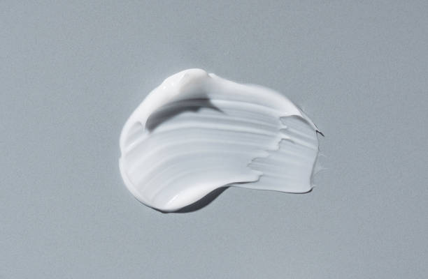 White cosmetic cream on gray background. White cosmetic cream on gray background. Cosmetic BB make up swatch. Drop of liquid foundation strokes. makeup swipes stock pictures, royalty-free photos & images