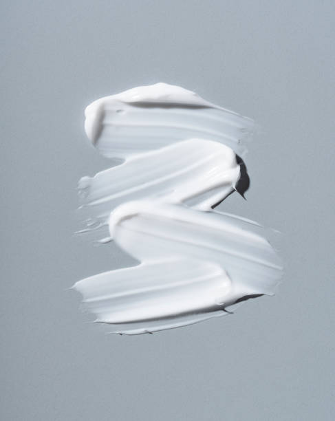 White cosmetic cream on gray background. White cosmetic cream on gray background. Cosmetic BB make up swatch. Drop of liquid foundation strokes. makeup swipes stock pictures, royalty-free photos & images