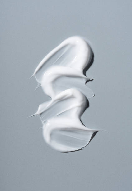 White cosmetic cream on gray background. White cosmetic cream on gray background. Cosmetic BB make up swatch. Drop of liquid foundation strokes. makeup swipes stock pictures, royalty-free photos & images