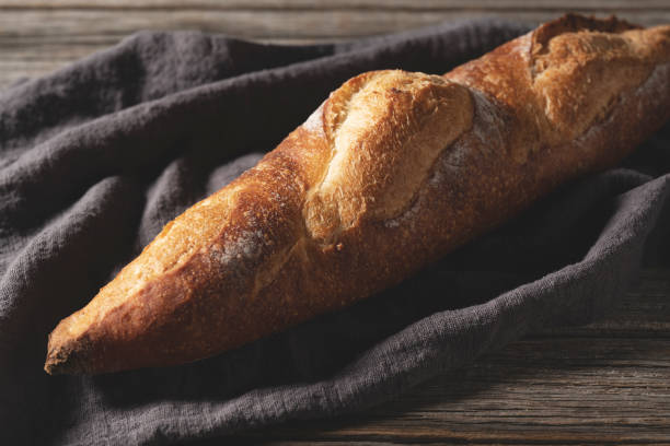 istock A cloth and baguette set against an old wooden background. Text space. 1353366318