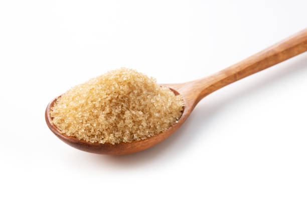 istock Wooden spoon and brown sugar on a white background. 1353366416
