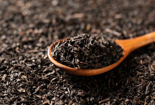 istock Background with tea leaves and a wooden spoon throughout the screen. 1353366655
