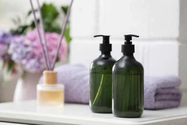 istock Soap dispensers and clean towel on white table. Space for text 1353366820