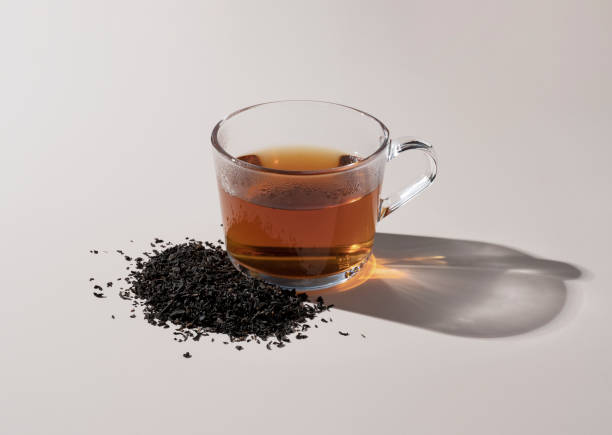istock Warm tea and tea leaves in a glass on a beige background 1353366997