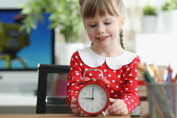 istock Little girl learning how to understand time and playing with red vintage clock 1353368938