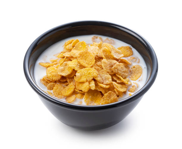 istock Milk and cornflakes in a black bowl on a white background 1353370074