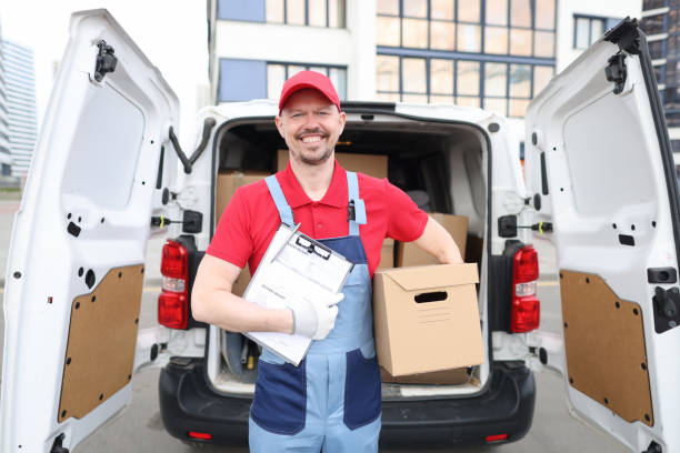 istock Smiling man holding a box and a delivery document 1353370163
