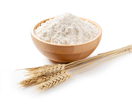 Ears of wheat and flour in a wooden bowl on a white background. Close-up, Material Photo
