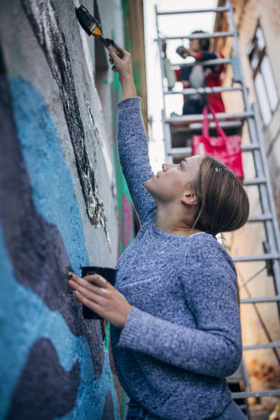 istock Artist painting on building wall 1353371513