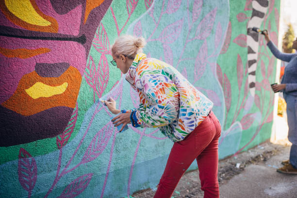 Female artists painting on building wall