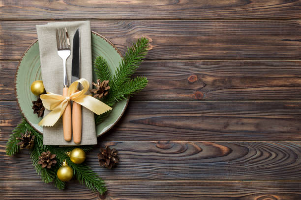 istock Christmas table place setting with christmas decor and plates, kine, fork and spoon. Christmas holiday background. Top view with copy space 1353373448