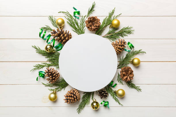 istock Flat lay Christmas composition. Round Paper blank, pine tree branches, christmas decorations on Colored background. Top view, copy space for text 1353373507
