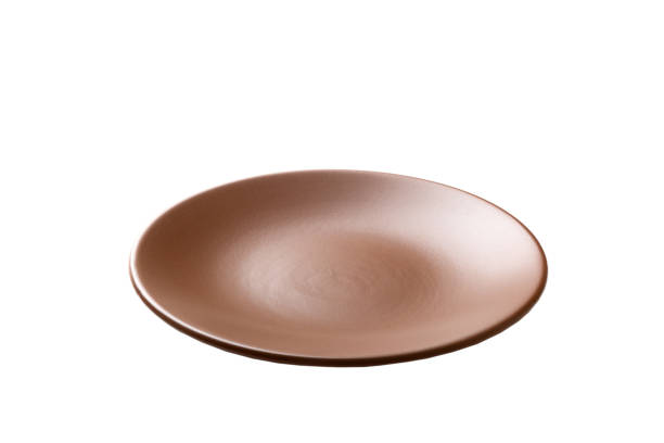 istock Brown color ceramic round plate isolated over white background. perspective view 1353373594