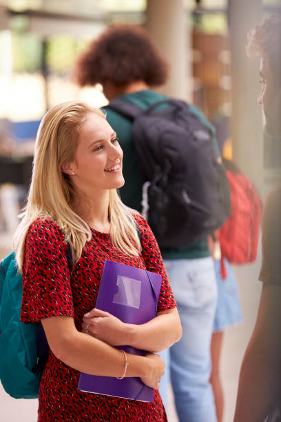 istock Smiling Female Student In Busy University Or College Building 1353374204