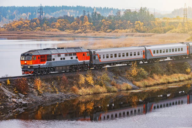 el tren de pasajeros se mueve a lo largo del lago en la mañana de otoño. carelia. - república de karelia rusia fotografías e imágenes de stock