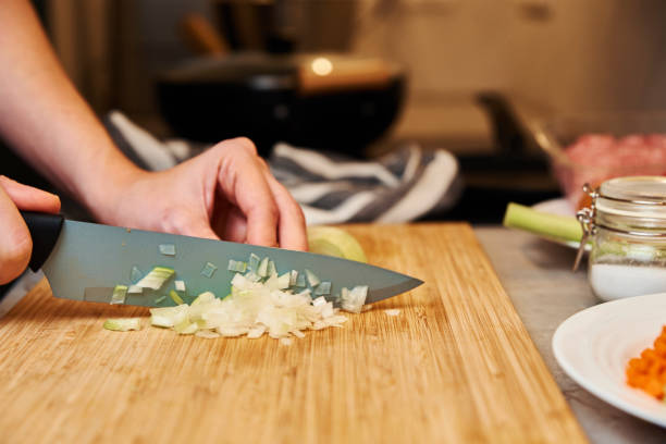 istock Woman chopping onion in kitchen, close up 1353374402