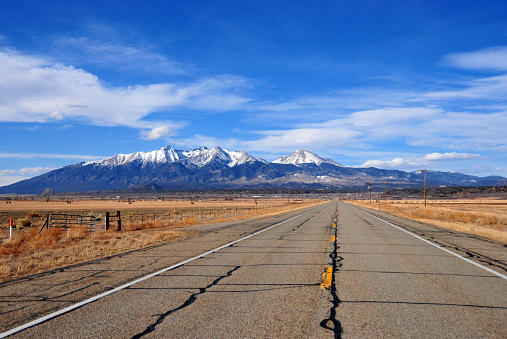 Fort Garland, Costilla County, Colorado, USA: Rocky mountains with snow in the background - Blanca Peak and Mount Lindsey, both fourteeners - Sierra Blanca Massif in the Sangre de Cristo Range of the Rocky Mountains of North America - quintessential American west road. The ultra-prominent (14,351-foot - 4,374 m) Blanka peak is the highest summit of the Sierra Blanca Massif, the Sangre de Cristo Range, and the Sangre de Cristo Mountains.