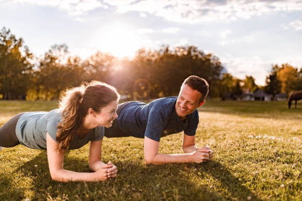 istock Happy athletic couple talking in plank position at the park. 1353377215