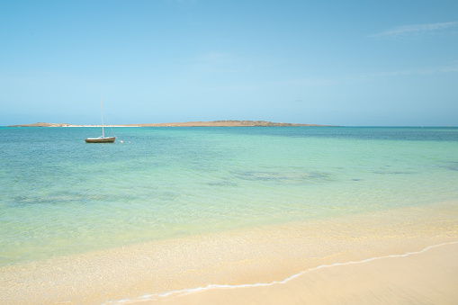 A small boat bobs around on the clear waters of Boa Vista, one of the Cape Verde islands.