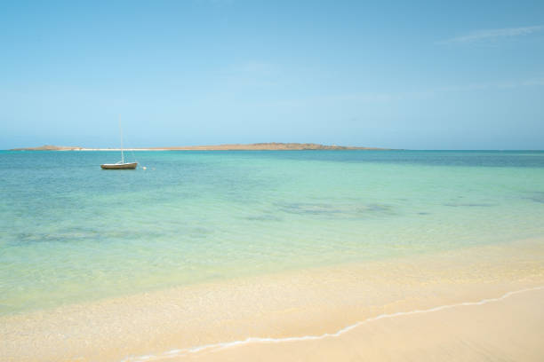 Blue Waters Of Cape Verde A small boat bobs around on the clear waters of Boa Vista, one of the Cape Verde islands. west africa coast photos stock pictures, royalty-free photos & images