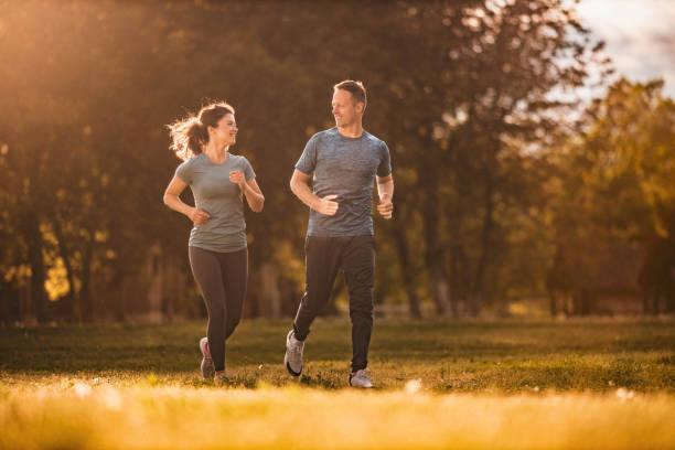 istock Happy athletic couple talking and running in nature. 1353377413