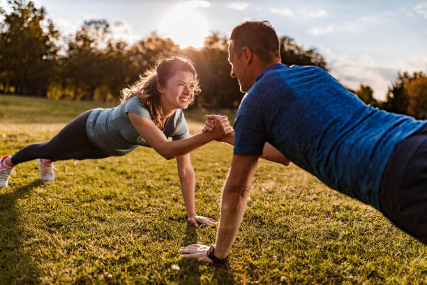 istock Happy athletic couple cooperating while exercising strength in nature. 1353377530