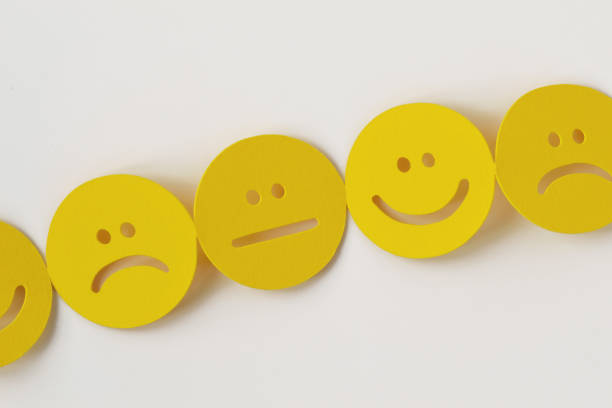istock Chain of paper faces with positive, neutral and negative expression on white background 1353377895