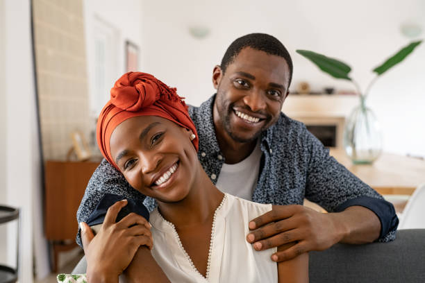 istock Cheerful black couple embracing at home 1353378725