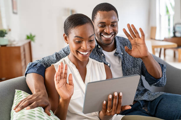 istock Happy smiling african couple doing video call with digital tablet at home 1353378960