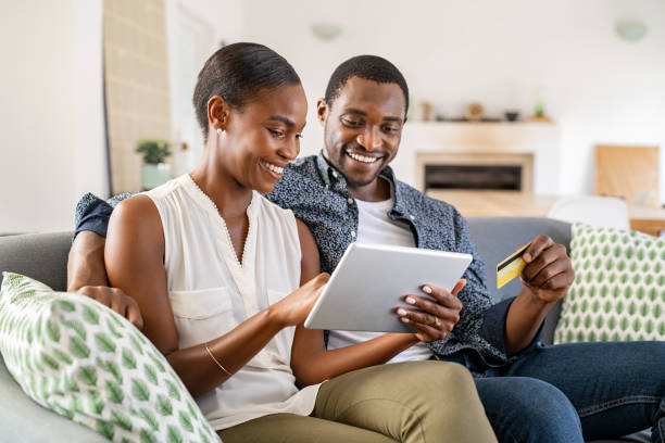 afroamerikanisches paar mittlere erwachsene, das eine kreditkarte für online-einkäufe verwendet - wallet couple stock-fotos und bilder