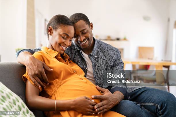 Black Expectant Parents Sitting On Sofa Dreaming About Their Baby 照片檔及更多 懷孕 照片
