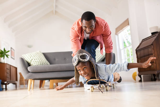 vater und sohn spielen zusammen mit skateboard - fathers family fathers day child stock-fotos und bilder