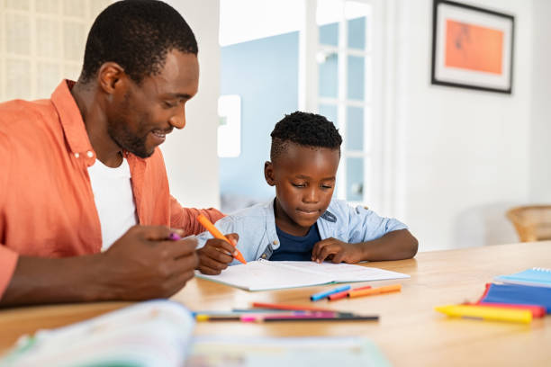 istock Mature black father helping son with homework 1353379323