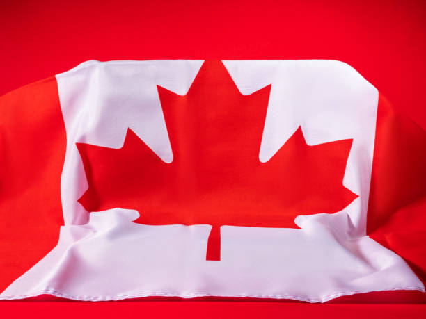 istock Canadian maple leaf flag on podium on red podium background 1353379458