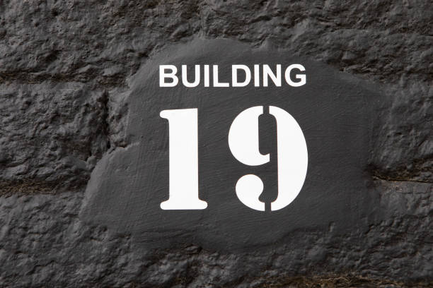 Building 19 painted in white on a black brick wall
