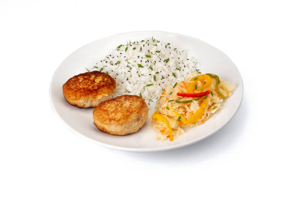 ð¡perder chuletas caseras de pescado frito o pollo con arroz y ensalada con chucrut en plato blanco aislado. gourmet, porción. receta del menú del banner. - fish cutlet fotografías e imágenes de stock