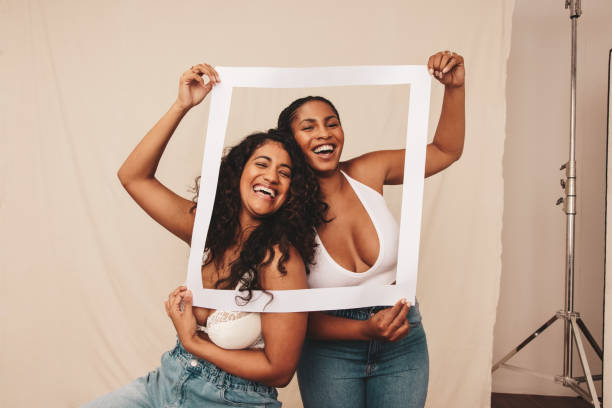 istock Friends laughing through a picture frame in a studio 1353381888