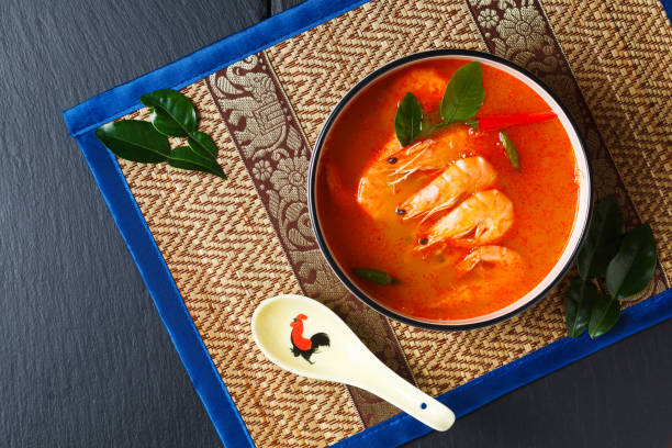 concetto di cibo del sud-est asiatico gamberetti tom yum tailandesi fatti in casa su tovagliette in stile tailandese con spazio di copia - tom tom yum meal soup foto e immagini stock