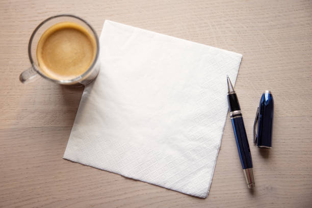 White napkin on the table with cup of coffee and a pen stock photo