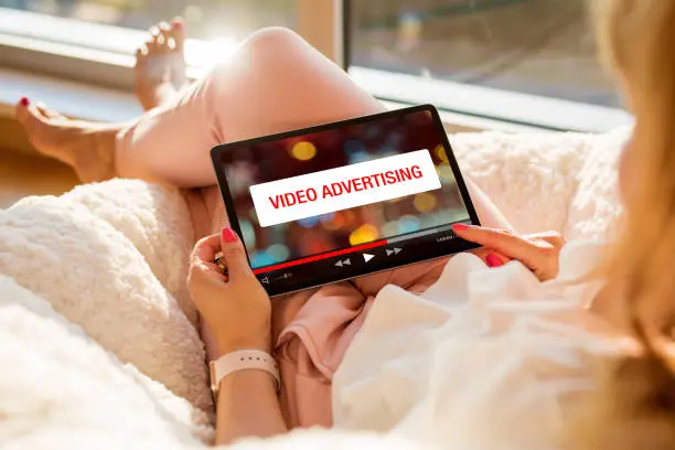 Photo of Concept of video marketing, woman looking at ad banner while watching videos online on tablet