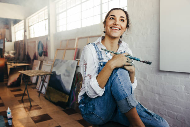 istock Excited female painter smiling in her art studio 1353384203