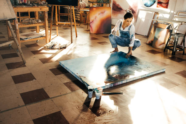 istock Female painter working on a new painting in her atelier 1353384298
