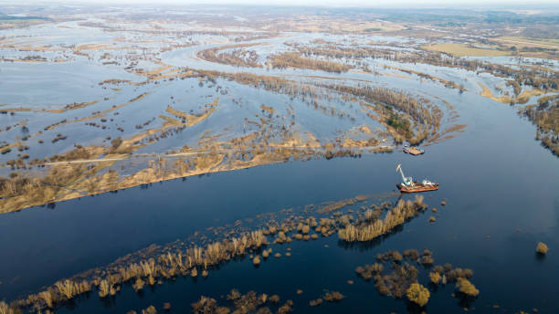 istock Floating crane on the river. Dredging crane working near shore. Conservation river flow. Nature, river, sky, clouds. 1353385825