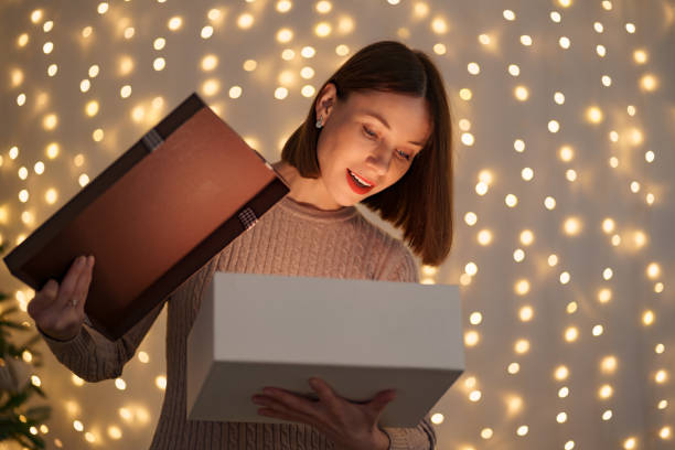 istock Happy beautiful woman opening a gift 1353386485
