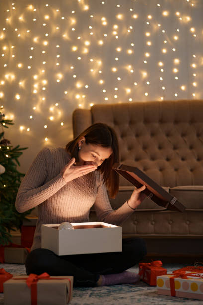 istock Happy beautiful woman opening a gift 1353386573