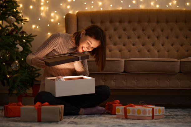 istock Happy beautiful woman opening a gift 1353386583