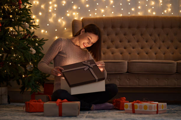 istock Happy beautiful woman opening a gift 1353386623