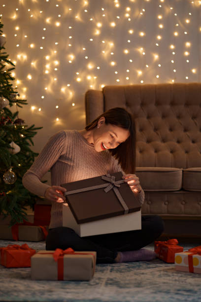 istock Happy beautiful woman opening a gift 1353386636