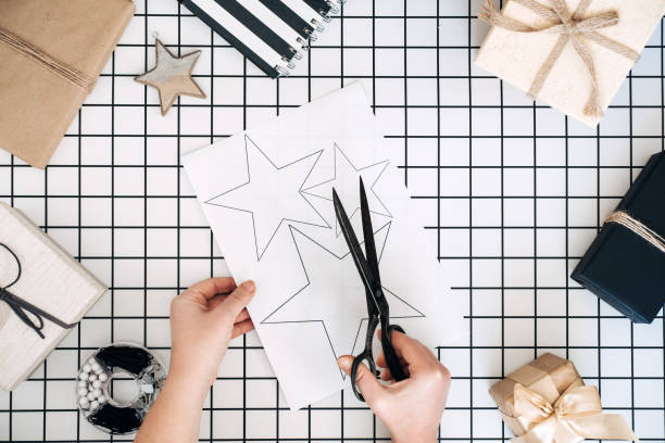 Creative gift wrapping ideas. Personalized gifts. Modern black and white flat lay with gift wrapping process. scissors, wrapped craft boxes and wrapping tools on white checkered background