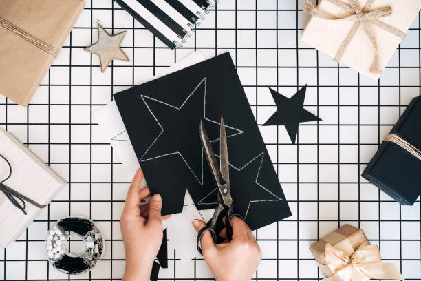 istock Creative gift wrapping ideas. Personalized gifts. Modern black and white flat lay with gift wrapping process. scissors, wrapped craft boxes and wrapping tools on white checkered background 1353387935